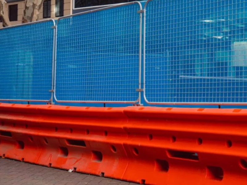 men discussing in front of barriers